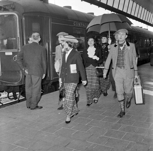 856617 Afbeelding van enkele gekostumeerde leden van het Rotterdams Studenten Corps op een van de perrons van het ...